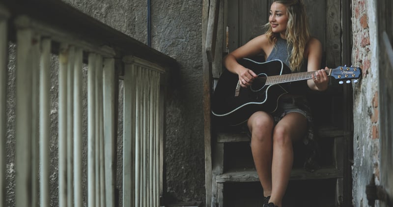 Woman Wearing Gray Tank Top Playing Black Cutaway Acoustic Guitar