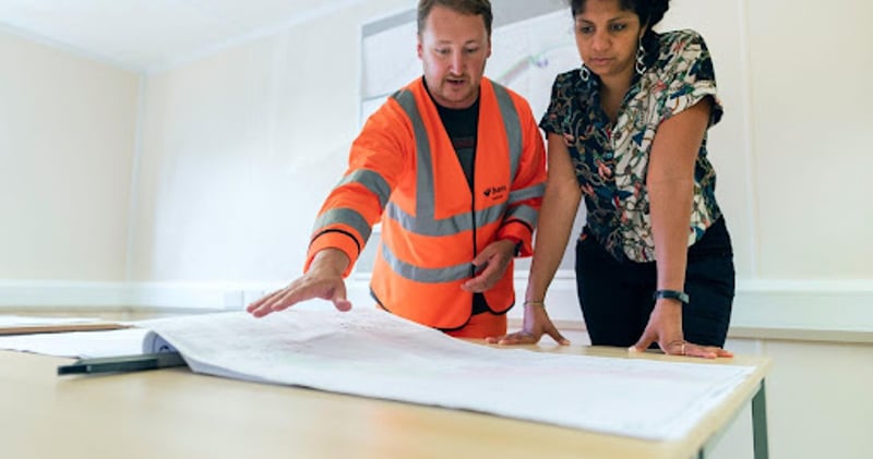 Engineer and woman looking at schematic