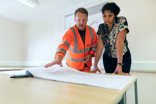 Engineer and woman looking at schematic