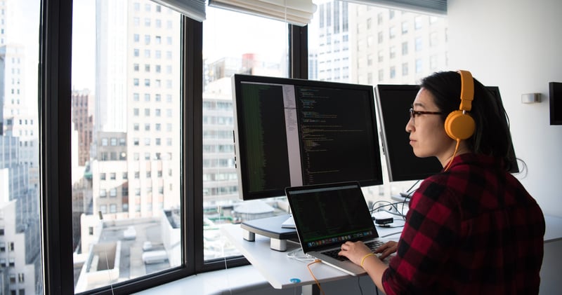 Woman standing While Operating Macbook Pro