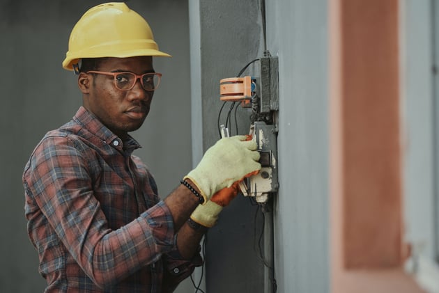 An Electrician Repairing a Fuse Box
