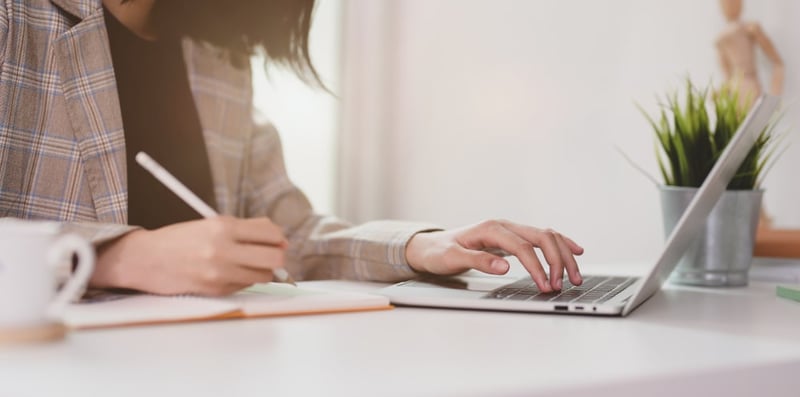 woman writing resume with strong action verbs