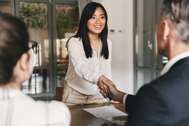 Woman shaking hands across the interview table