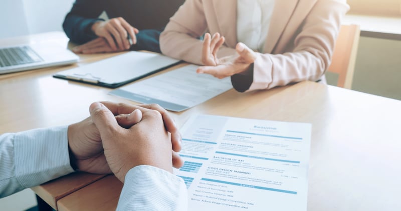 People discussing a resume at a table