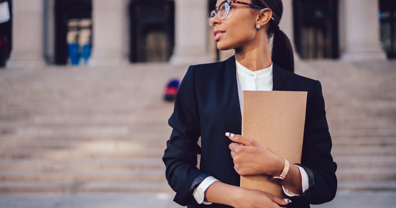Woman carrying a folder in front of steps